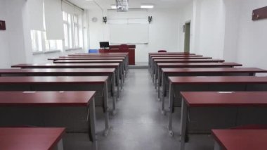 Boş üniversite konferans salonunda ahşap masalarla yavaş yavaş ilerliyorlardı. Covid 19 salgını yüzünden etrafta kimse yoktu.