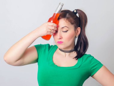 Genç bir kızın portresi alkol onun elinde bir şişe. Sarhoş kız. Akşamdan kalma. İçtikten sonra baş ağrısı.