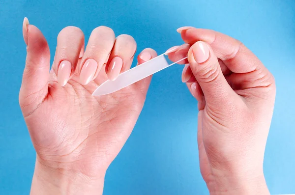 Mujer Haciendo Una Manicura Con Una Lima Cristal Sobre Fondo —  Fotos de Stock