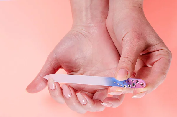 Manikür çivi kadın cam törpü pembe bir arka plan üzerinde