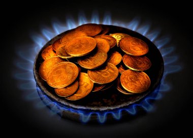 Coins of Ukraine lie on the gas burner of the kitchen stove. Expensive gas in Ukraine. Saving money. clipart