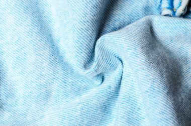 Açık mavi kot kumaşı spiral şeklinde bükülmüş modern moda tasarımı ve günlük kıyafet kavramları için yumuşak tekstil arka planı oluşturur