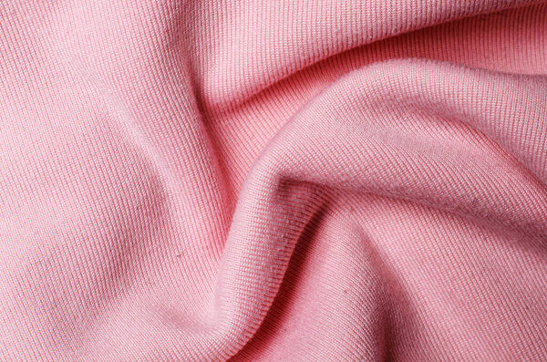 Морщинистая светло-розовая полиэфирная ткань создает текстурированный текстильный фон для современного модного дизайна и стильных концепций интерьера