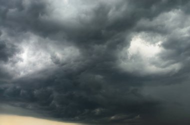 Koyu fırtınalı gökyüzü, zıt gri ve beyaz bulutlar hava, iklim ve güçlü doğa kavramları için dramatik bir atmosfer yaratıyor.