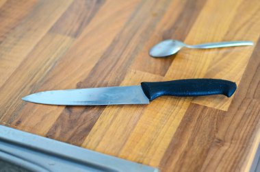 Kitchen knife on table with blurred teaspoon in background view