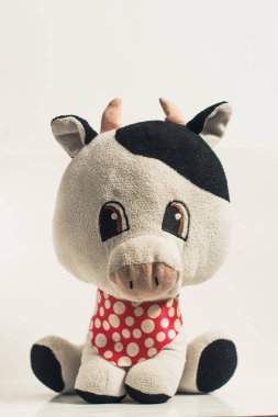 Doldurulmuş inek, bebekler için oyuncak ve beyaz soyutlanmış arka planda çocuklar..