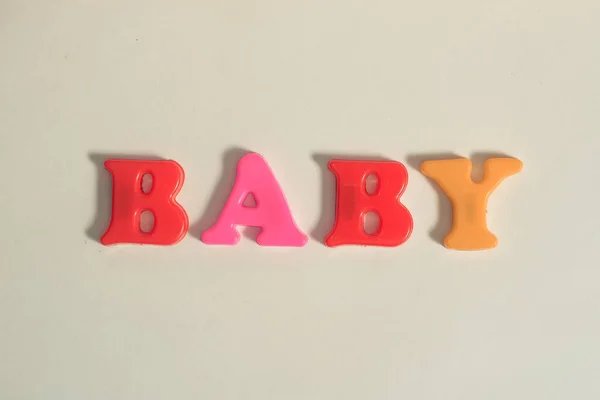 Letras de plástico mensagem bebê no fundo isolado branco — Fotografia de Stock