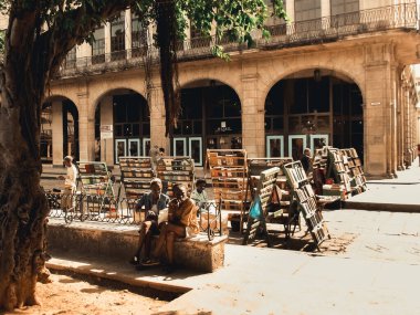 Havana, Küba - 18 Eylül 2019: Havana 'nın merkezindeki Eski Kasaba Meydanı' nda çok sayıda insan yürüyor, iki yerli konuşuyor, barok mimarisini ve koloni binalarını vurguluyor