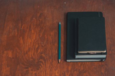 İzole edilmiş ahşap zemin üzerinde kalem çizimi olan kapalı defterler