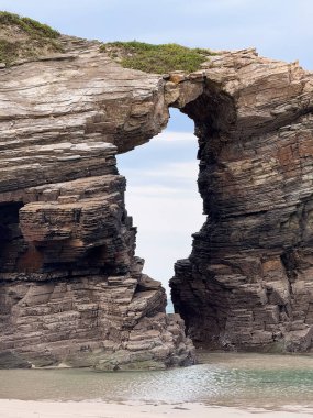 Playa de las Catedrales, İspanya 'da yatay katmanlı kaya kemeri oluşumu.