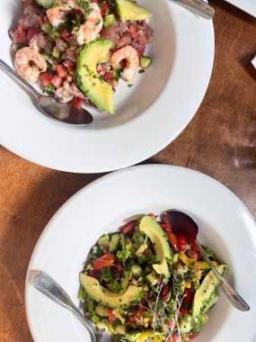 Meksika 'da ahşap bir masada servis edilen avokado dilimli taze karides ceviche..