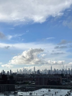 New York şehrinin ufuk çizgisi gün boyunca mavi bir gökyüzünün altında kabarık bulutlarla fotoğraflandı..