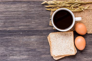 Buğday, yumurta ve kahve kulakları, koyu ahşap masa background.top üzerinde ekmek ile kopya alanı ile göster