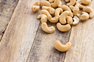 Kaju fıstığı kahverengi ahşap bir masa üzerinde dağınık