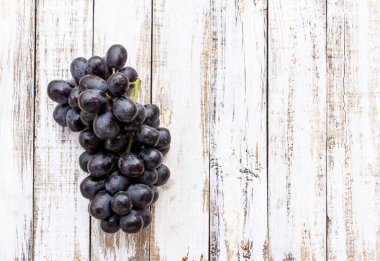 Beyaz ahşap masa arka plan üzerinde üzüm. Üstten Görünüm