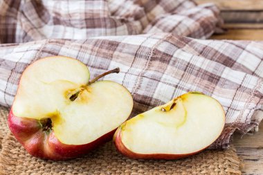 Ahşap bir masa üzerinde bir dilimlenmiş kırmızı elma kapatın. Eski ahşap masa arka plan üzerinde taze kırmızı elma. ahşap masa üzerinde kırmızı ve yeşil elma