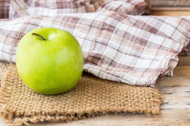 Çuval bezi, eski ahşap masa arka plan üzerinde yapraklarda ile yeşil elma. sağlıklı yemek ve healhcare konsept tasarımı için için yeşil elma