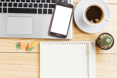 Dizüstü bilgisayar, kahve fincanı, not defteri, kalem ve akıllı telefon ile ofis resepsiyon masası. Üstten Görünüm kopya alanı ile. İş kavramı