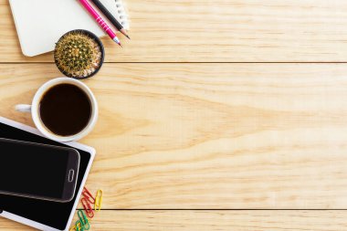 Dizüstü bilgisayar, kahve fincanı ve akıllı telefon ofis resepsiyon masası. Kopya alanı ile Üstten Görünüm