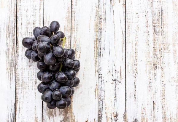 Beyaz ahşap masa arka plan üzerinde üzüm. Üstten Görünüm