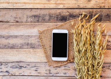 Buğday ve eski ahşap masa arka plan akıllı telefon. kopya alanı ile Üstten Görünüm