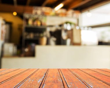 Ürün gösterimi için seçili boş kahverengi ahşap masa ve kahve dükkanı arka planı bulanık