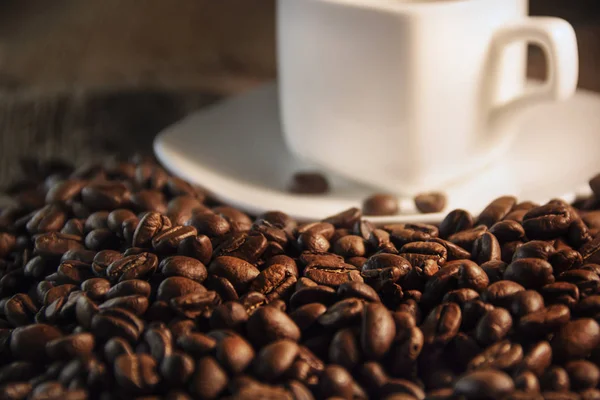 Copo branco e café grãos aromáticos de marrom — Fotografia de Stock