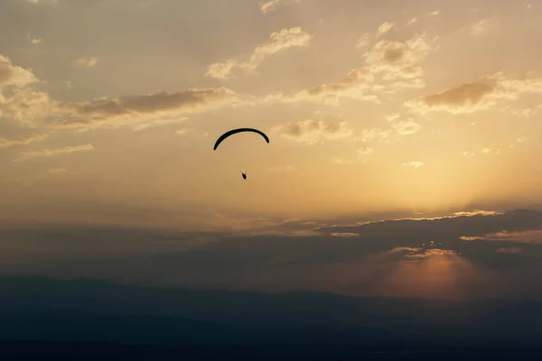 Paraglider flies in the clouds at sunset, background, blur — Stock Photo, Image