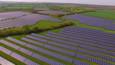 İngiltere 'nin Northamptonshire kentindeki bir güneş çiftliğindeki büyük güneş paneli dizilerinin hava görüntüsü.