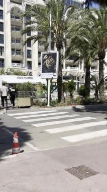 Cannes, Fransa - 27 Mayıs 2023: Cannes 'da Cannes Film Festivali sırasında çekilen lüks sergiler ve palmiye ağaçları ile Louis Vuitton mağazası.
