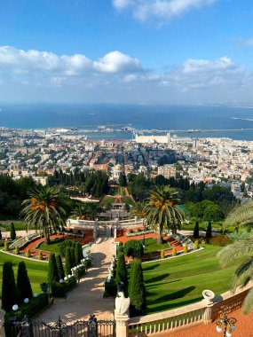 Hayfa, İsrail - Mavi gökyüzü altında Akdeniz 'e uzanan manikürlü teraslar, palmiye ağaçları ve panoramik şehir manzaralı Bahai Bahçeleri.