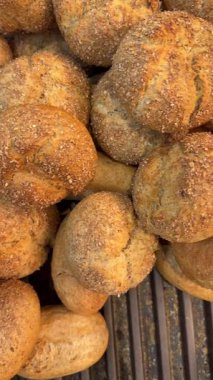 Fırın tepsisine istiflenmiş küçük yuvarlak ekmek rulolarının videosunu kapat. Taze zanaatkar çörekleri tasarım için bir gıda arkaplanı sağlar.