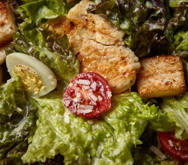 Sağlıklı salata, ızgara tavuklu marul yaprakları ve parmesan peynirli haşlanmış yumurta dilimleri. Yayın amaçlı yemek fotoğrafçılığı için tasarlandı..