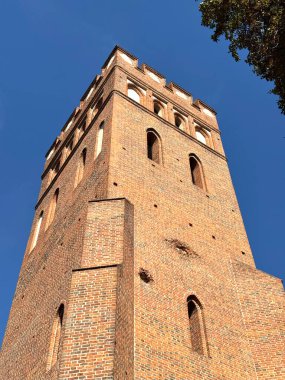 14. yüzyıl gotik tuğla kilise kulesinin dikey görüntüsü 1370 yılında Avrupa 'da açık mavi gökyüzünün altında inşa edildi. Ortaçağ mimarisi savunma tasarımı ve dini mirası gösteriyor..