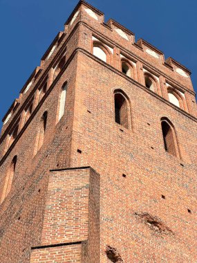 1370 'te Avrupa' da inşa edilen ortaçağ gotik tuğla kilise kulesine yakın perspektif. Mavi gökyüzü altında tarihi mimari ve kültür mirası.