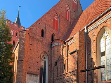 1370 yılında Avrupa 'da inşa edilen uzun kemerli camları, destekleri ve çatı çizgisi olan gotik tuğlalı katolik kilisenin geniş kenar manzarası.