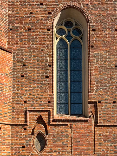 1370 'te Avrupa' da inşa edilen ortaçağ Katolik kilisesinin tuğladan duvarına yerleştirilmiş gotik vitray penceresinin ayrıntılı bir yakın çekimi. Dini işçilik ve mimari örnekleri.