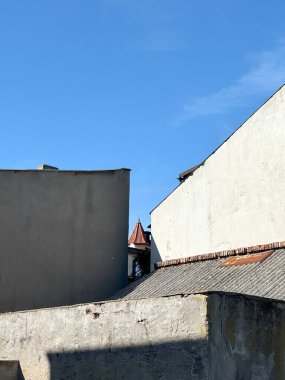 Şehir manzarası ön planda çatıları ve düz duvarları gösteriyor. Arka planda tarihi kale kulesi var. Sahne, kopyalama alanı ile kentsel mimari karşıtlığı vurguluyor.