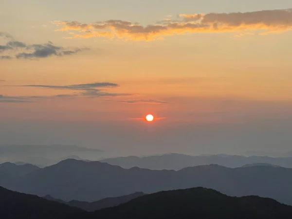 Altın gün doğumu gökyüzünü sıcak renklerle boyar, dağların aydınlık katmanları uzaklığa doğru kaybolur, nefes kesici bir panoramik manzara yaratır.