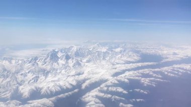 Himalayalar 'ın yüksek irtifa manzarası, bulutların üzerinde yükselen görkemli kar tepeleri, el değmemiş el değmemiş vahşi doğayı ve uçak uçuşundan ilham veren manzaraları.