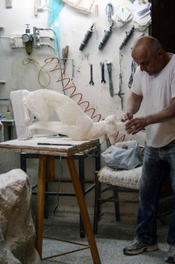 At Volterra - Italy - On 01/08/2018 - sculptor at work in his workshop clipart