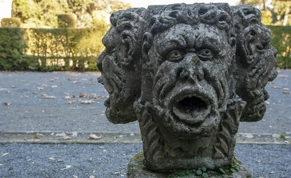 three faces head sculpture in the  italian garden of rinascimental villa lante Bagnaia, Viterbo. Lazio, Italy