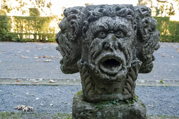 three faces head sculpture in the  italian garden of rinascimental villa lante Bagnaia, Viterbo. Lazio, Italy