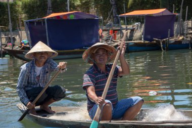 Hoi An Vietnam 'da Ağustos 2019' da Thu Bon nehrinde yüzen geleneksel bir teknede iki balıkçı.