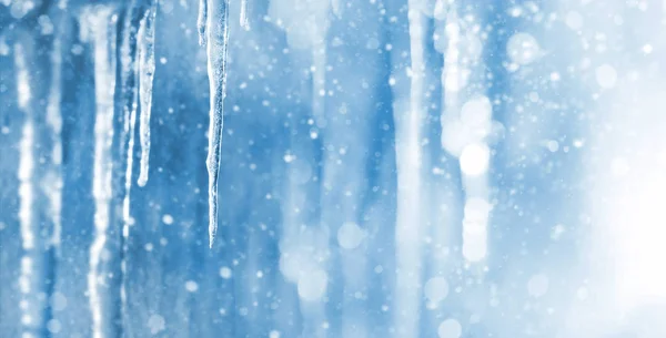 明亮的背景与冰柱 冬天背景与冰柱和下落的闪亮的雪 — 图库照片