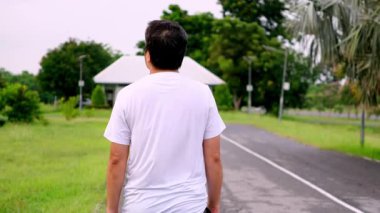 Orta yaşlı Asyalı bir adamın sabah yürüyüşü. Ortak-dost kardiyo, aktif yaşlanma ve barışçıl açık hava sağlığını teşvik ediyor. Sağlık hizmetleri video konsepti.
