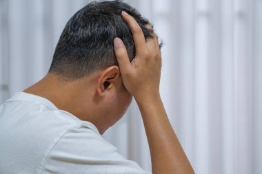 Orta yaşlı Asyalı bir adamın yoğun bir işten sonra başını ağrıtması stresten kaynaklanan baş ağrısına işaret ediyor. Nörolojik bakım, migren ve stres atma reklamları için mükemmel..