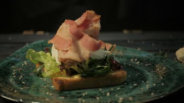Breakfast. Poached egg, bacon on lettuce made from toast. — Stock Video