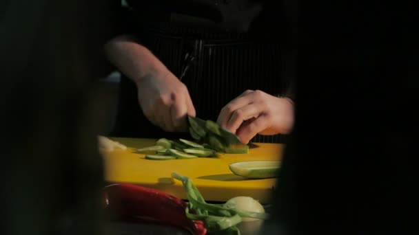 Close-up van chef-kok handen snijden komkommer in restaurant keuken — Stockvideo