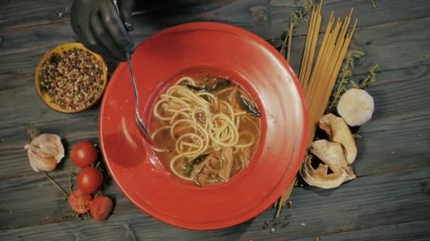 Mushroom soup with spaghetti paste. Top view. On a black wooden background. Copy space. — Stock Video